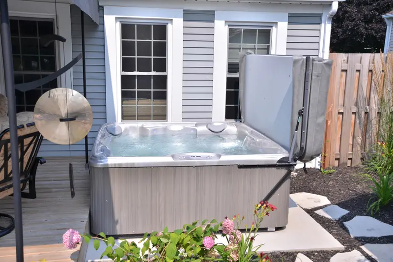 Hot tub beside house with flowers