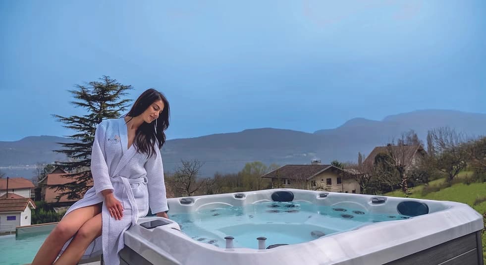 Woman relaxing by hot tub with mountain view